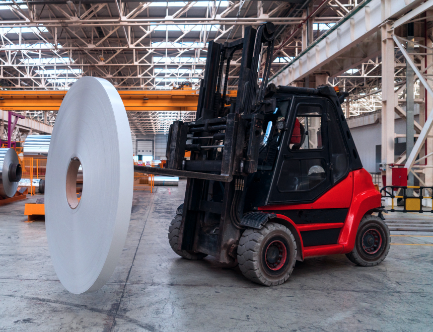 Forklift transporting a large roll of aluminum coil in an Silver Sailing industrial warehouse